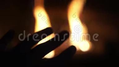 观点：人在燃烧的壁炉前搓手，温暖的手，舒适的家